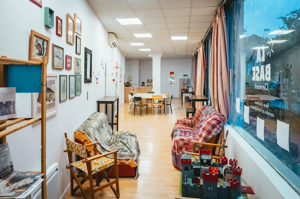 Untitled photo de l'intérieur de la base avec la partie cosy en premier plan, des gros canapés et la salle de réunion et le bar en arrière plan